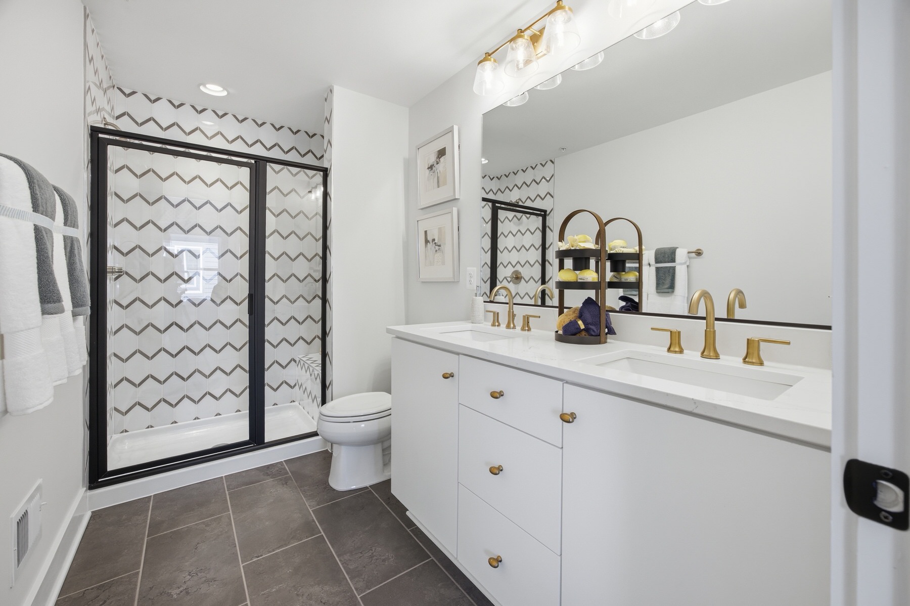 Bathroom with chevron tile walk-in shower and gold fixtures, real estate photography Central Maryland