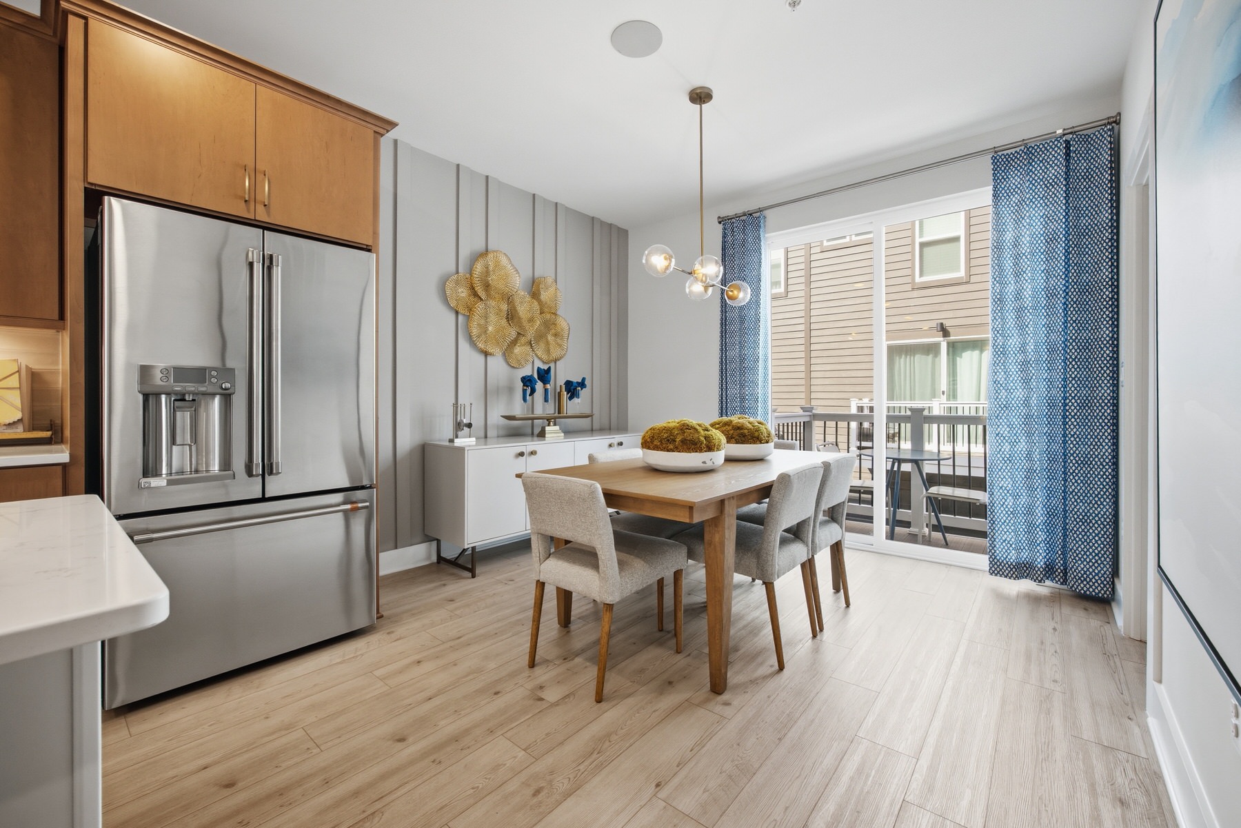 Dining area with warm wood cabinets and stainless refrigerator, real estate photography Central Maryland