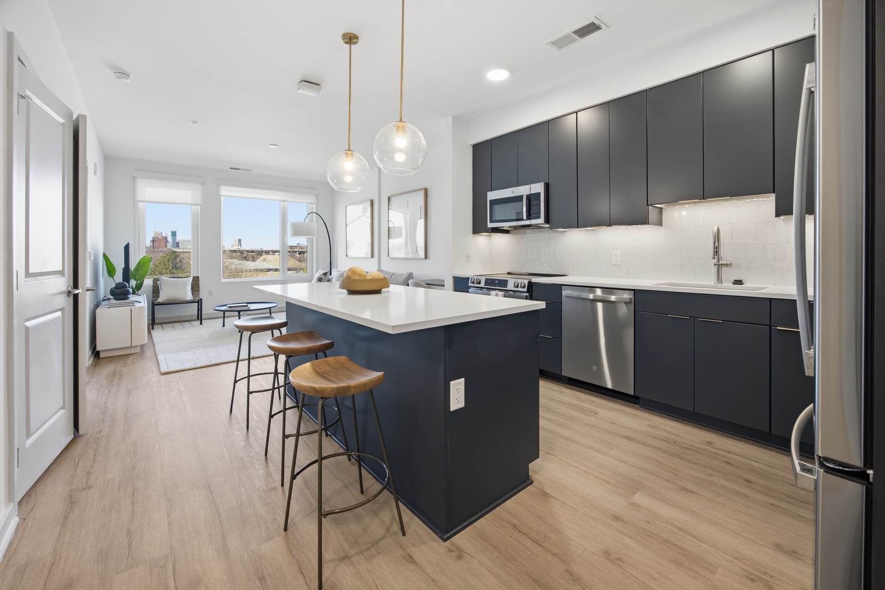 Modern open-plan kitchen with navy cabinets and island, real estate photography Baltimore MD