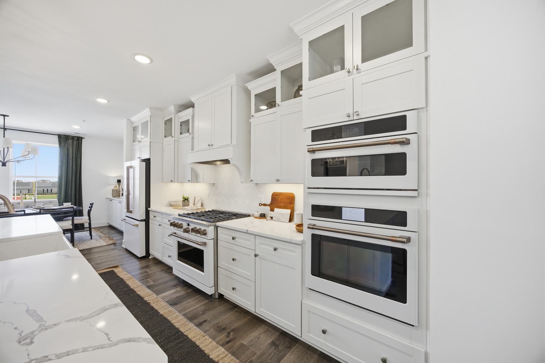 Kitchen with white Café appliances, double wall ovens, and marble counters, real estate photography Central Maryland