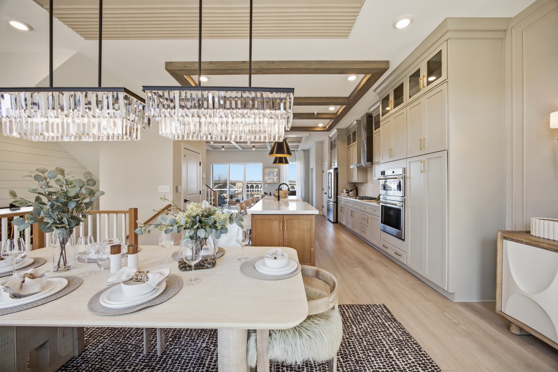 Open-plan dining and kitchen with crystal chandelier and set dining table, real estate photography Central Maryland
