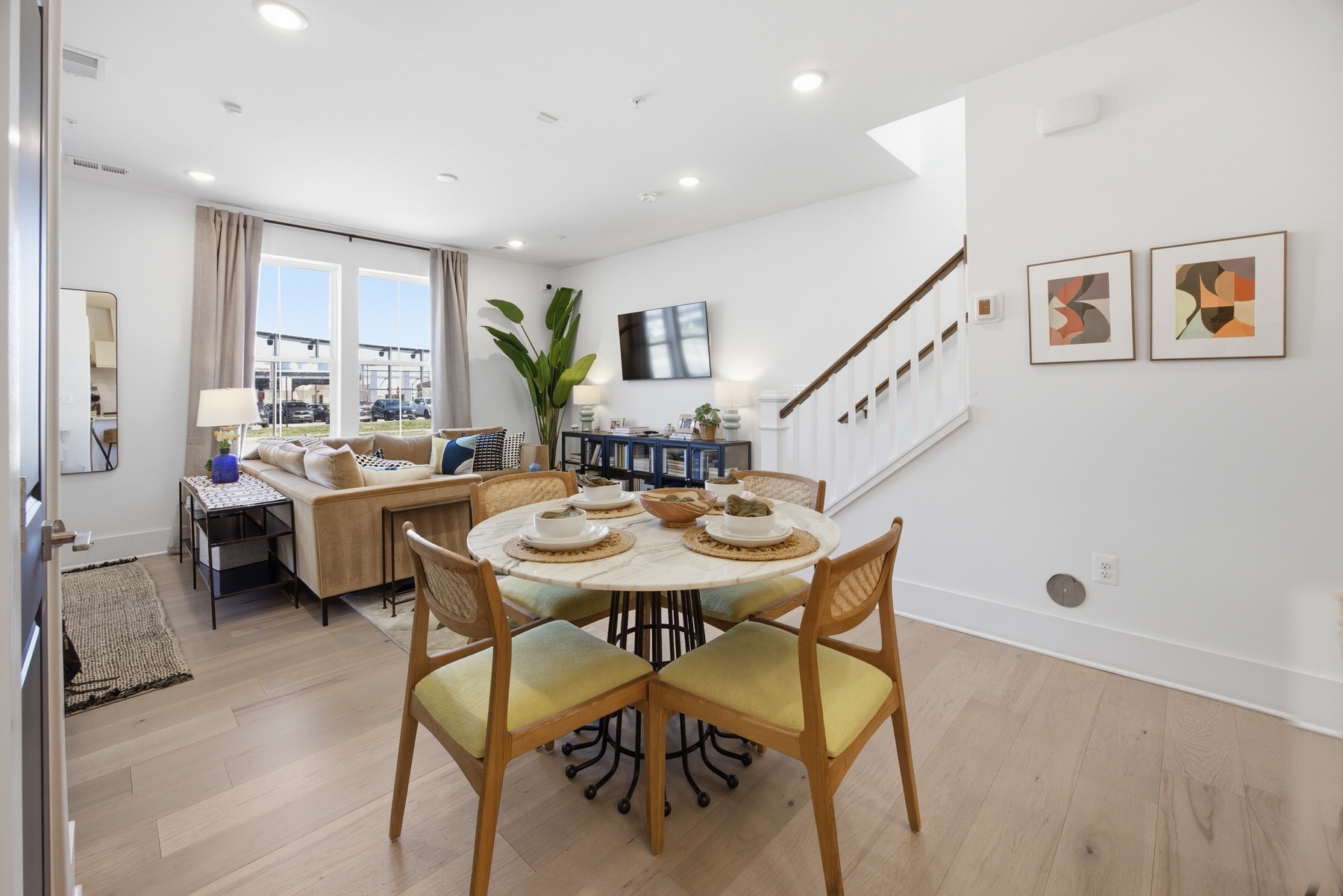 Open-plan dining and living area with staircase and natural light, real estate photography Baltimore MD