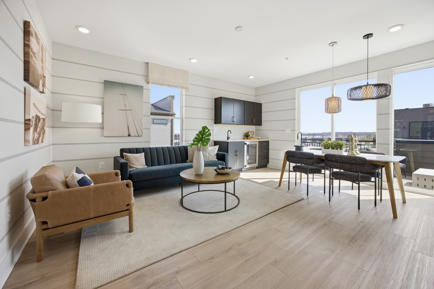 Open-plan living and dining with coastal decor and shiplap accent wall, real estate photography Baltimore