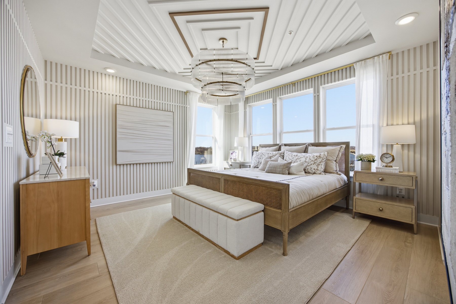 Primary bedroom with striped wallpaper, chandelier, and large windows with views, real estate photography Central Maryland
